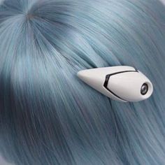 a close up view of a blue wig with a hair clip in the shape of a rocket ship