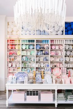 a white table topped with lots of crafting supplies next to a chandelier