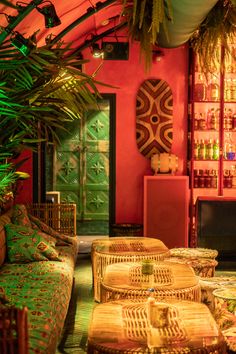 a living room filled with lots of wicker furniture next to green plants and potted plants