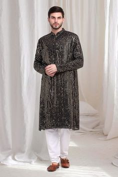 Black kurta with striped sequin work embroidery. Paired with solid churidaar. - Aza Fashions Embroidered Party Wear Kurta With Traditional Drape, Traditional Party Wear Kurta With Mirror Work, Party Wear Long Sleeve Kurta For Diwali, Festive Long Sleeve Traditional Party Wear, Festive Long Sleeve Party Traditional Wear, Party Wear Long Sleeve Kurta For Festive Occasions, Festive Party Wear Embellished Kurta, Festive Long Sleeve Party Wear Kurta, Festive Long Sleeve Party Kurta