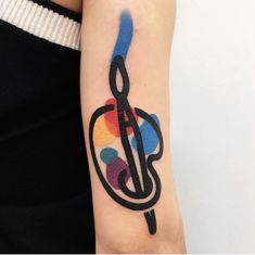 a colorful tattoo on the arm of a woman's left arm, with an abstract design