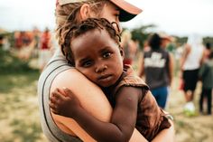 a woman holding a child with the words what's volunteerism? and is it good as it seems?