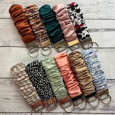 several different types of headbands are lined up on a white wooden surface with metal clips