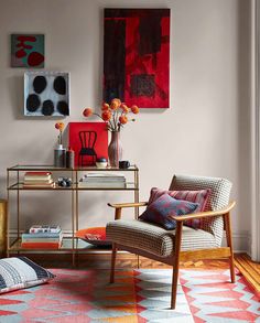 a living room filled with furniture and paintings on the wall above it's coffee table