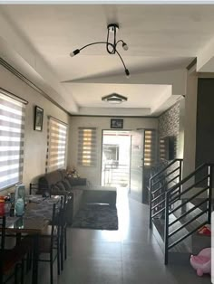 a living room filled with furniture and windows covered in blind shades on top of them