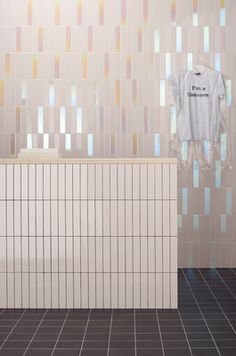 a bathroom with tiled walls and flooring next to a bathtub in front of a mirror