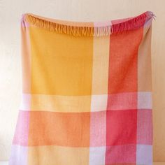 an orange and pink checkered blanket on a table