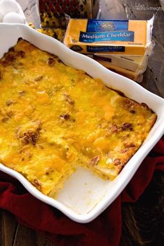 a casserole dish with meat and cheese in it on a table next to eggs