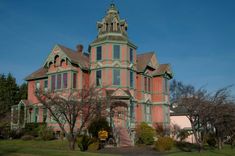 an old pink and green house on a sunny day