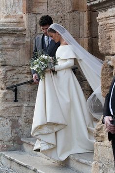 the bride and groom are walking down the stairs