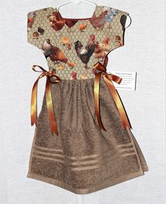 a dress made out of fabric with chickens on it and gold ribbon around the waist