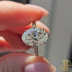 a close up of a person holding a ring with a diamond in it's center