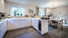 a kitchen with a large clock mounted to the wall next to a dining room table