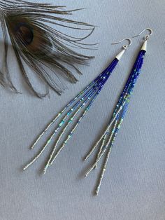 "Wind Crest" A playful harmony of cool navy blue and silver seed beads rest against threads of bright blue and sky blue. These long earrings feature a splash of mixed color accents. A pop of electric tribal colors make these earrings a true statement to wear. 925 silver earwires finish the look. The last photo shows a similar pair of 9 inch earrings worn for scale. Please choose your length at check out: 4 inches 6 inches 9 inches Photos show our long pair of earrings measuring 6 inches from top of earwire to bottom. Your jewelry will come beautifully packaged and ready to give as a gift. Each piece comes in a hand decorated brown paper gift box.  For multiple purchase orders - Please let me know in the "notes to seller" upon checkout if you need your order packed in separate gift bags or Cheap Elegant Blue Beaded Earrings, Handmaid Jewelry, Long Beaded Earrings, Color Accents, Paper Gift Box, Handmade Jewelry Diy, Beaded Dangle Earrings, Bracelet Tutorial, Cool Necklaces