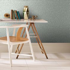 a desk with a chair and books on it in front of a wallpapered background