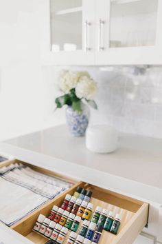 a wooden box filled with lots of different colored paints on top of a white counter