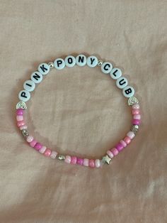 A hand-crafted glass bead friendship bracelet highlighting Chappell Roan's song "Pink Pony Club"! A simple and cute way to show off your favorite song or a great concert accessory!  This bracelet is made with Czech glass beads, plastic letter beads, plastic spacer beads, and is on an elastic thread measured at about 10 inches in length for a relaxed/loose fit. If you would like the bracelet you order to be smaller or larger, please leave the requested size in inches in the personalization box! Adjustable Kpop Bracelets With Round Beads, Adjustable Beaded Kpop Bracelets, Trendy Pink Beaded Bracelets With Letter Beads, Pink Beaded Kpop Bracelets, Adjustable Round Beads Kpop Bracelets, Pink Kpop Beaded Bracelets, Kpop Pink Beaded Bracelets, Casual Pink Friendship Bracelets With Heart Beads, Pink Name Bracelet With Colorful Beads For Friendship