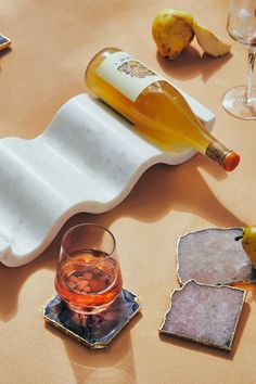 a bottle of wine sitting on top of a table next to glasses and coasters