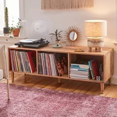 a record player sitting on top of a wooden shelf next to a table with records