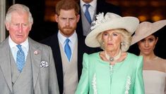 the prince and princess of wales are standing next to each other in front of two men