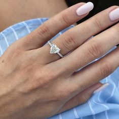 a woman's hand with a ring on her finger and a pink manicure