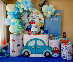 a blue car themed birthday party with balloons and streamers on the wall behind it