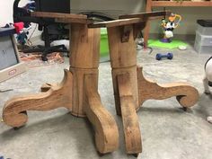 a small wooden table sitting on top of a floor next to a laptop computer monitor