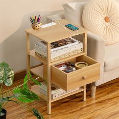 a small wooden table with two drawers and a phone on it next to a couch