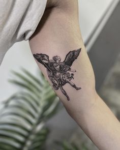 a woman's arm with a black and white tattoo of an angel on it