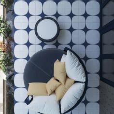 an overhead view of a circular table with pillows on it and a chair in the background