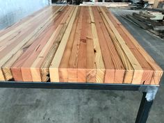 a large wooden table with metal legs in a warehouse or workshop area, ready to be used as a workbench