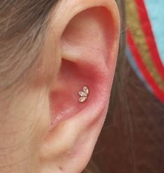 a close up of a person's ear with a small diamond stud in the middle