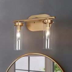 two lights that are on the side of a wall next to a mirror and window