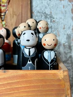 a group of wooden toy figures sitting on top of a wooden box next to a wall