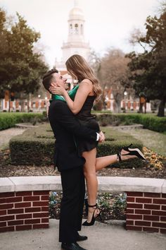 a man and woman are hugging in front of a building