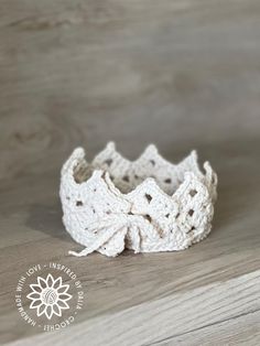 a crocheted white ring sits on a wooden surface