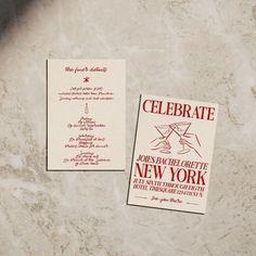 two cards with the words celebrate and new york written on them sitting on a marble surface