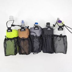 five water bottles are lined up in mesh bags