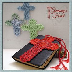 a crocheted book with a red cross on it next to an open bible