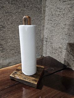 a white toilet paper holder sitting on top of a wooden block