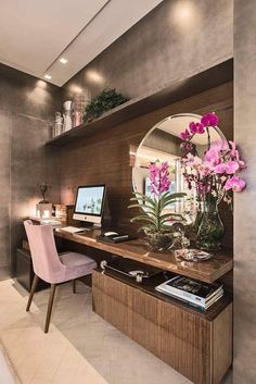 a room with a desk, mirror and flowers on the shelf next to each other