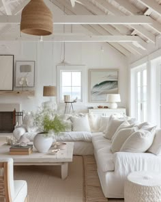 a living room filled with white furniture and lots of natural light coming through the windows