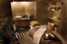 a spa room with candles and towels on the bed