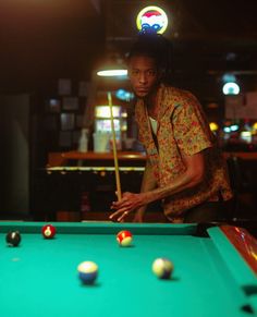 a man is playing pool in a bar