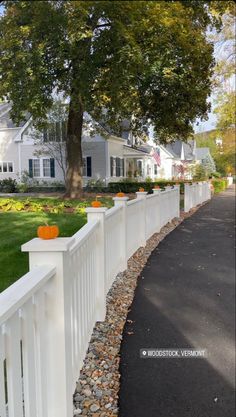 a white picket fence with pumpkins on it