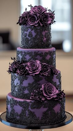 a purple and black wedding cake with roses on it