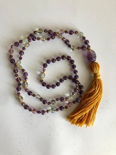 "Amethyst Japa Mala with Rainbow Fluorite  This mala sparkles and shimmers with calming and peaceful energy.  Its specialness begins and ends with the guru bead which is an Amethyst crystal engraved with the Shou symbol; a powerful Asian icon that represents longevity, happiness and harmonic life. A little bit about the enchanting energy of Amethyst: Amethyst is a beautiful stone of protection with a high spiritual vibration. This purple beauty has long been associated with the energy of the Crown Chakra and Third Eye for developing intuitive abilities, spiritual guidance and love for the divine. It is believed  that the energy of Amethyst exudes serenity which supports a peaceful state of mind for meditation practices. Magically, the healing power of Amethyst helps in healing physical ali Spiritual Multicolor Amethyst Crystal Necklaces, Purple Amethyst Necklace For Meditation, Lavender Handmade Necklace For Meditation, Handmade Lavender Necklace For Meditation, Spiritual Amethyst Multicolor Necklace, Multicolor Amethyst Spiritual Necklace, Spiritual Multicolor Amethyst Necklace, Purple Natural Stones Necklace For Meditation, Bohemian Amethyst Necklace With 108 Beads