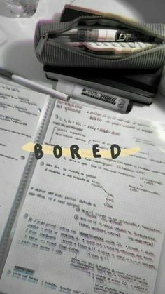 an open notebook with the word bored written on it