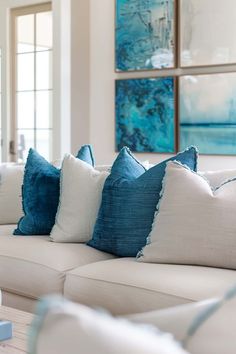 a living room filled with white couches and blue pillows