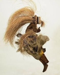 a man with long hair on his head is performing a trick in the air while holding onto a stick